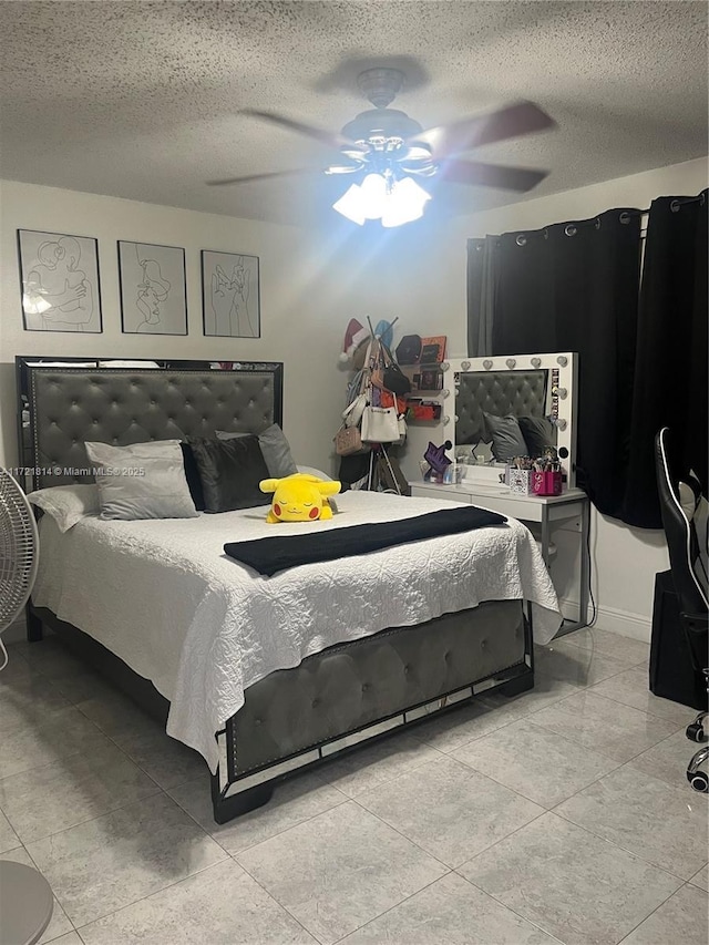 bedroom featuring ceiling fan, light tile patterned flooring, and a textured ceiling