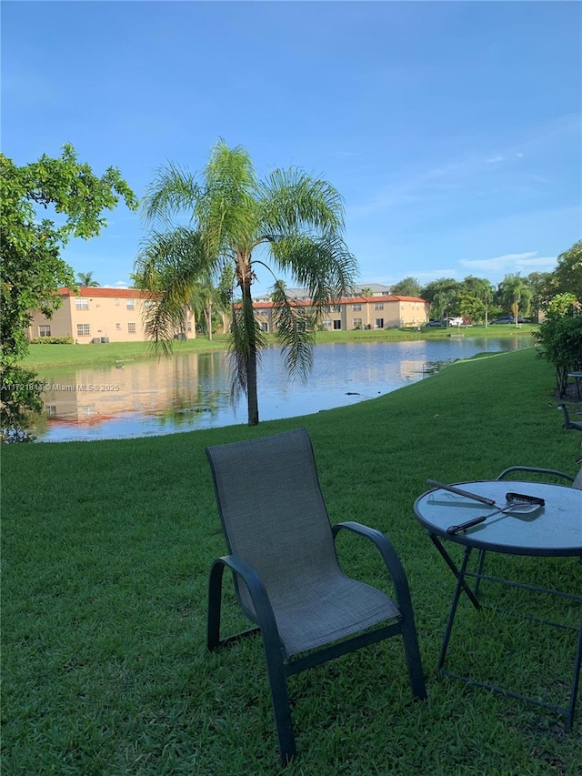 view of home's community with a water view and a yard