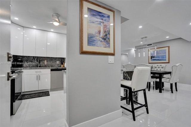 kitchen with white cabinets, decorative light fixtures, tasteful backsplash, ceiling fan, and stainless steel dishwasher