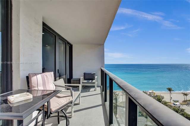 balcony featuring a view of the beach and a water view