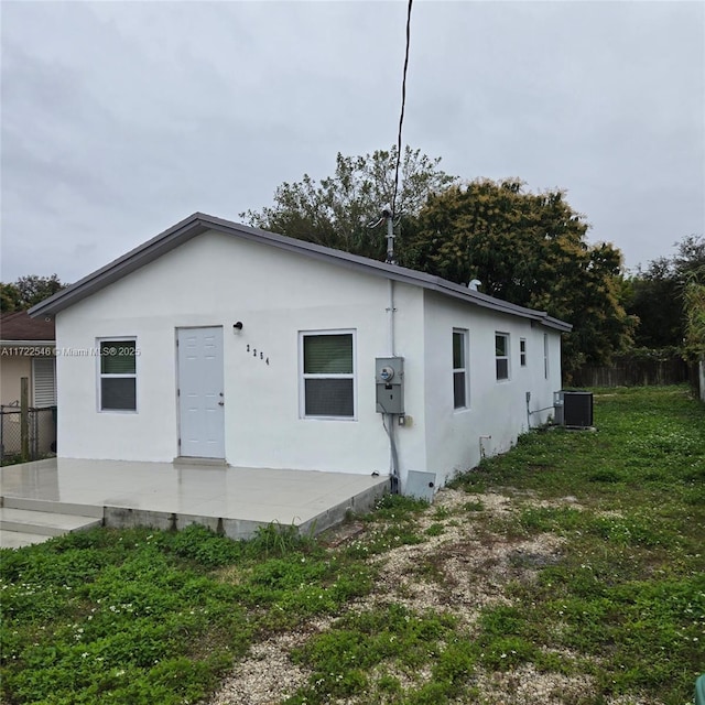 back of house featuring a yard and central AC