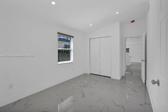 unfurnished bedroom with a closet and lofted ceiling