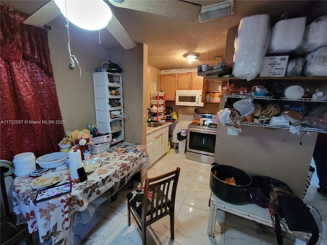 651 SW 5th St, Homestead, FL 33030 - kitchen featuring stainless steel electric stove, white microwave, light marble finish flooring, light countertops, and light brown cabinetry