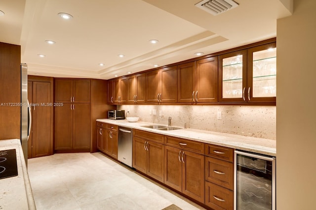 kitchen featuring light stone counters, wine cooler, tasteful backsplash, and sink