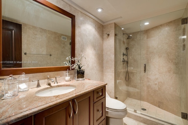 bathroom featuring vanity, toilet, and a shower with shower door