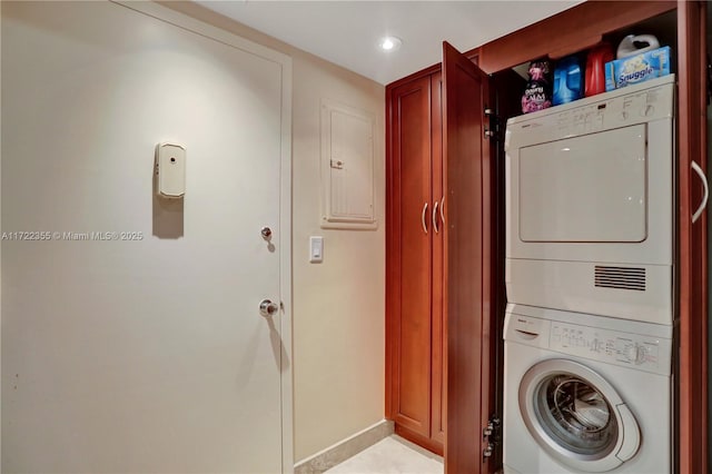 washroom featuring stacked washing maching and dryer and electric panel