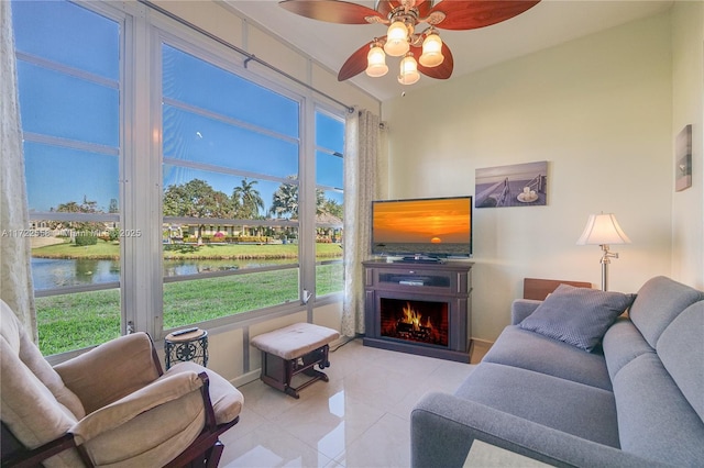 tiled living room with a water view and ceiling fan