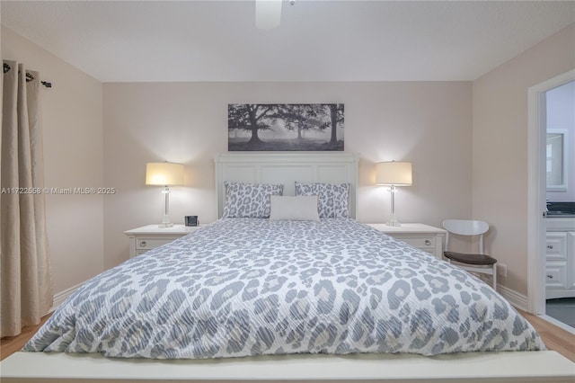 bedroom with ensuite bathroom, ceiling fan, and hardwood / wood-style flooring