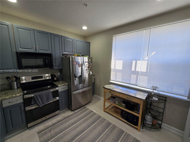 kitchen with stone counters, gray cabinets, a textured ceiling, and appliances with stainless steel finishes