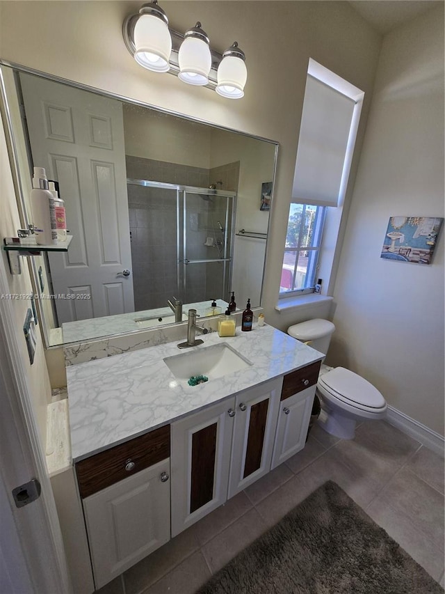 bathroom with toilet, vanity, tile patterned floors, and walk in shower