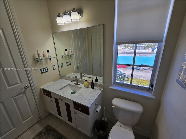 bathroom with tile patterned flooring, vanity, and toilet