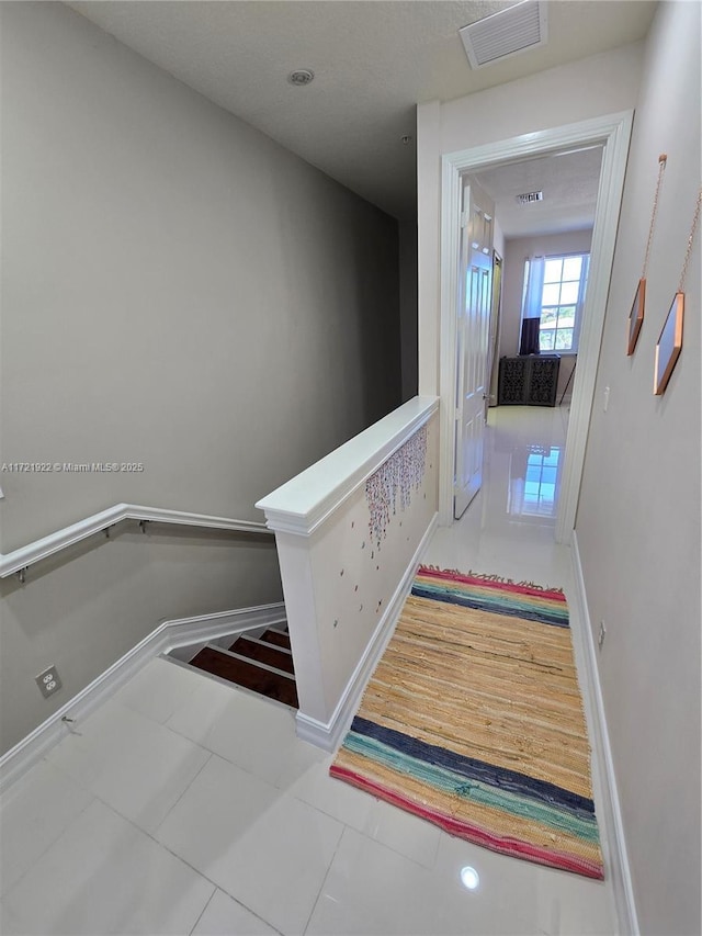 stairway with tile patterned floors