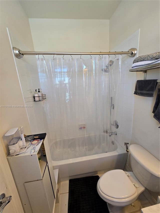 bathroom featuring tile patterned floors, toilet, and shower / bath combo with shower curtain