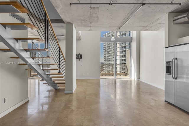 basement featuring stainless steel refrigerator with ice dispenser