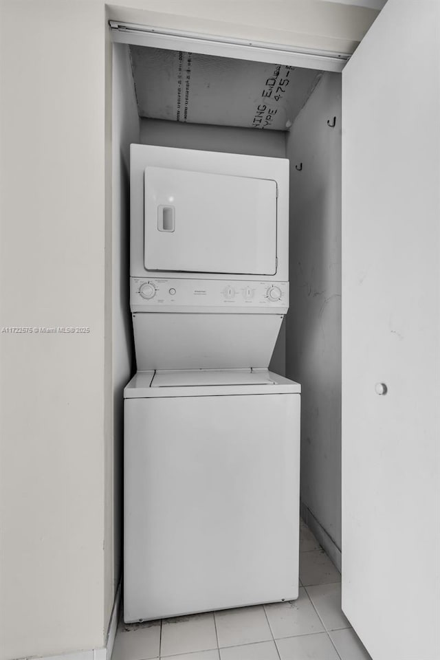 washroom featuring light tile patterned floors and stacked washer / dryer