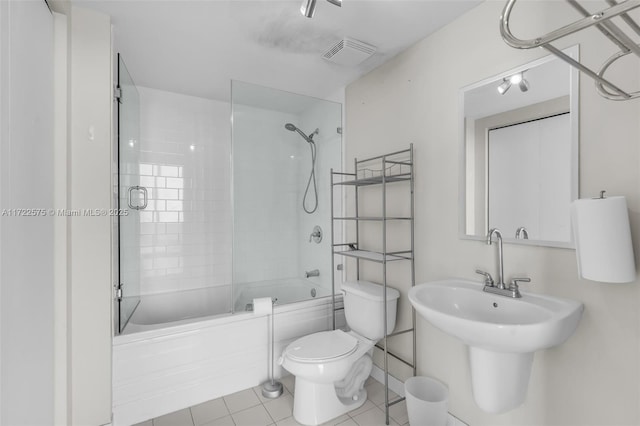 full bathroom featuring tile patterned flooring, toilet, combined bath / shower with glass door, and sink