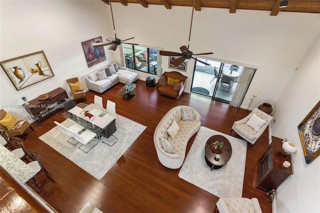 living room featuring ceiling fan, wooden ceiling, dark wood-type flooring, beamed ceiling, and high vaulted ceiling