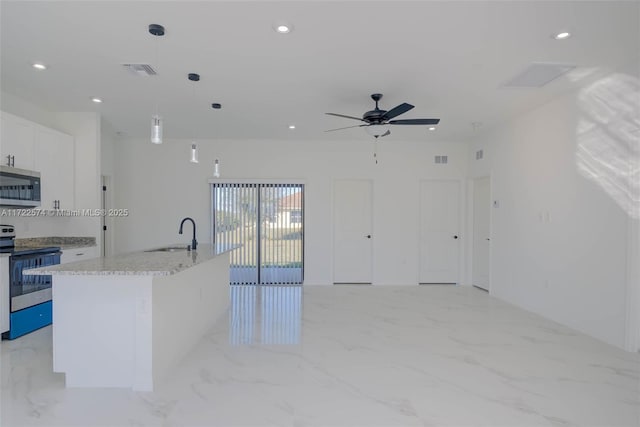 kitchen featuring light stone countertops, appliances with stainless steel finishes, pendant lighting, white cabinetry, and an island with sink