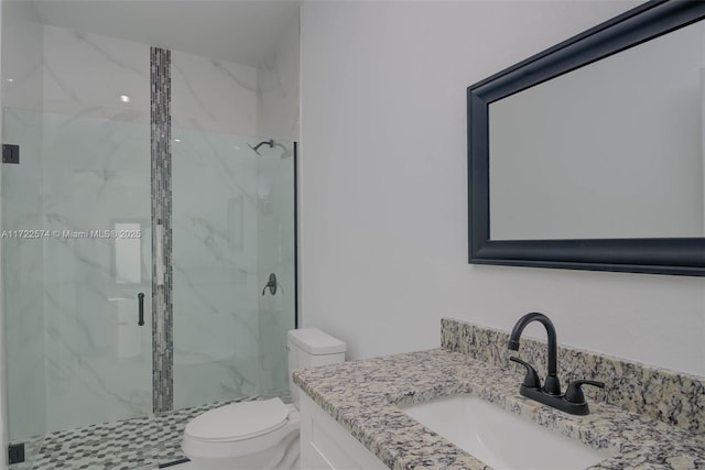 bathroom featuring a shower with door, vanity, and toilet