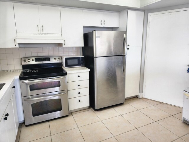1351 NE Miami Gardens Dr Unit 1025E, Miami, FL 33179 - kitchen with stainless steel appliances, under cabinet range hood, light countertops, backsplash, and white cabinets