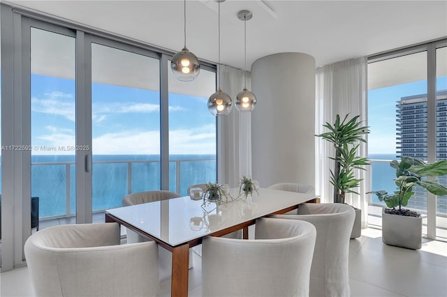 dining room featuring expansive windows and a water view