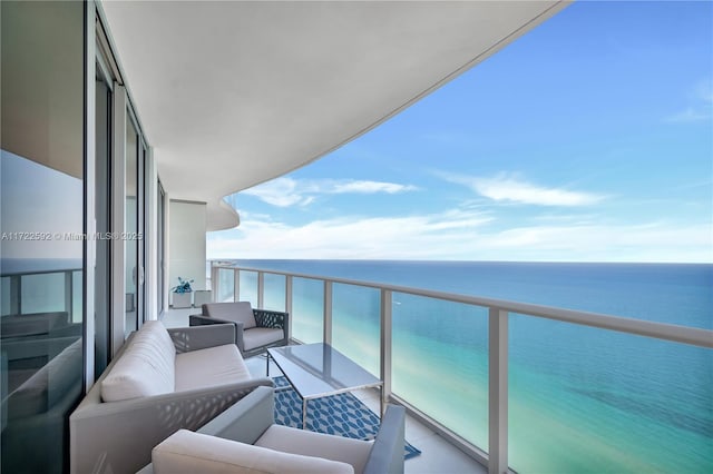 balcony with an outdoor living space and a water view