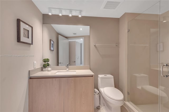 bathroom with vanity, toilet, and a shower with door