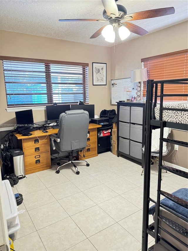 tiled office featuring ceiling fan and a textured ceiling