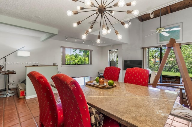 dining room featuring a textured ceiling, tile patterned flooring, ceiling fan with notable chandelier, and plenty of natural light