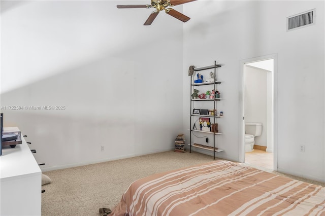 bedroom featuring carpet floors, ensuite bathroom, a towering ceiling, and ceiling fan