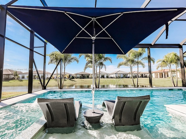 view of pool with a lanai, pool water feature, and a water view