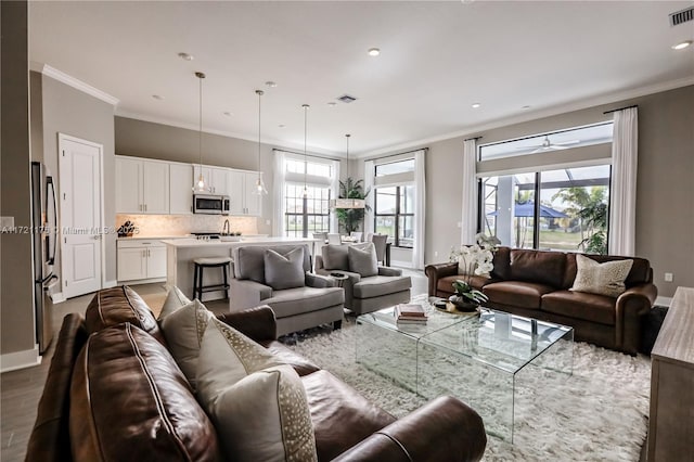 living room featuring ceiling fan, hardwood / wood-style floors, and ornamental molding