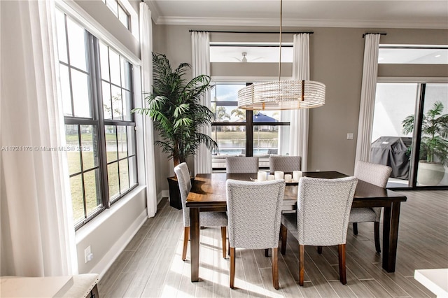 dining space featuring plenty of natural light, crown molding, and a chandelier