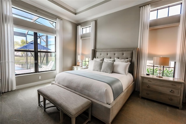 carpeted bedroom featuring a water view, ornamental molding, and multiple windows