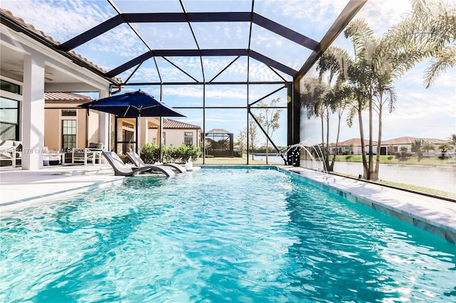 view of pool featuring pool water feature, glass enclosure, a patio area, and a water view