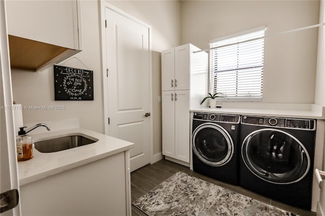 laundry area with cabinets, washer and dryer, and sink