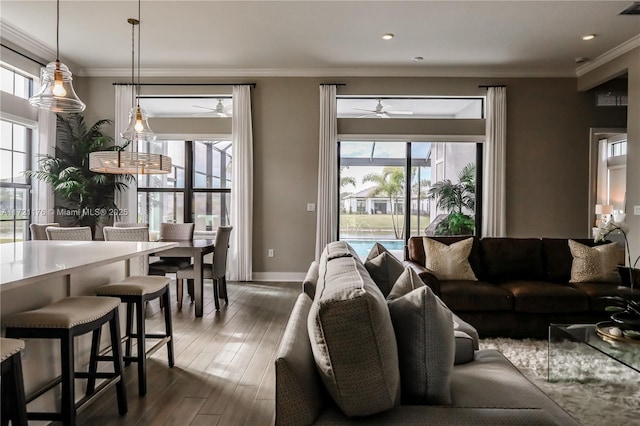 living room featuring ornamental molding, dark hardwood / wood-style flooring, ceiling fan, and a healthy amount of sunlight