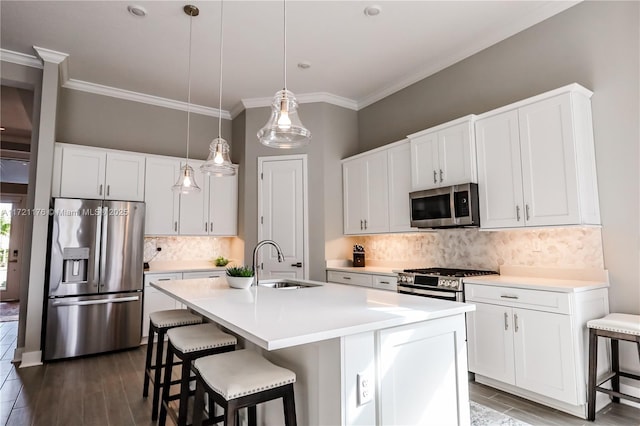 kitchen with appliances with stainless steel finishes, backsplash, a center island with sink, and sink