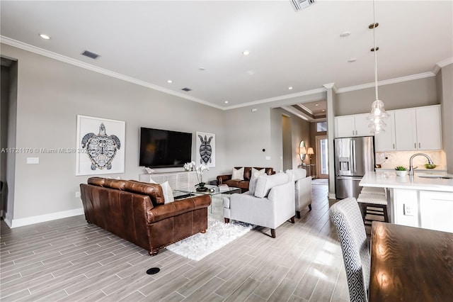 living room featuring ornamental molding and sink