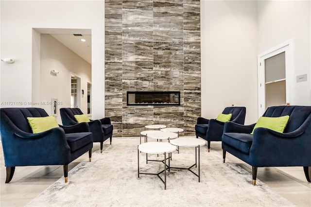 living room featuring a towering ceiling and a fireplace