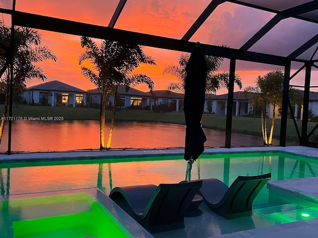 pool at dusk featuring glass enclosure