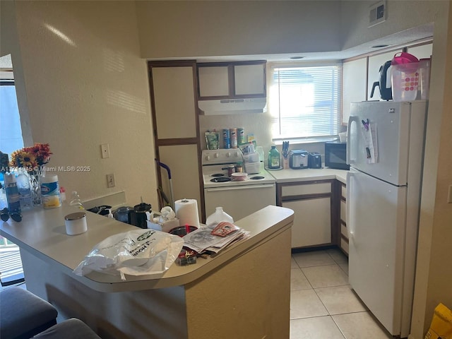 kitchen featuring kitchen peninsula, white cabinetry, light tile patterned flooring, and white appliances