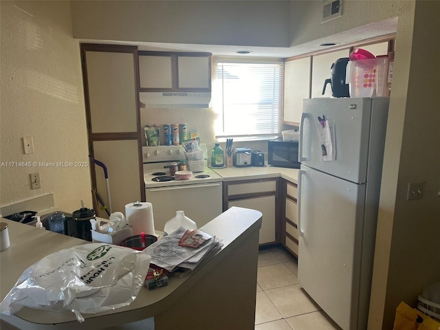 kitchen with white appliances and light tile patterned floors