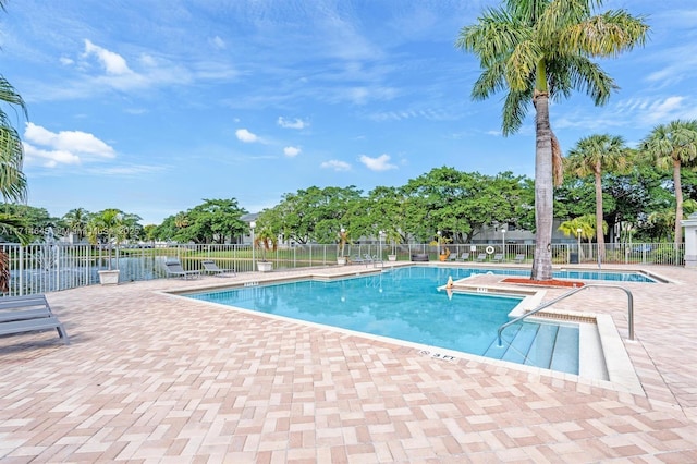 view of swimming pool featuring a patio area and a water view