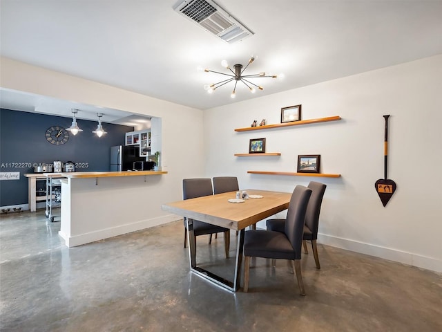 dining space featuring an inviting chandelier and concrete flooring