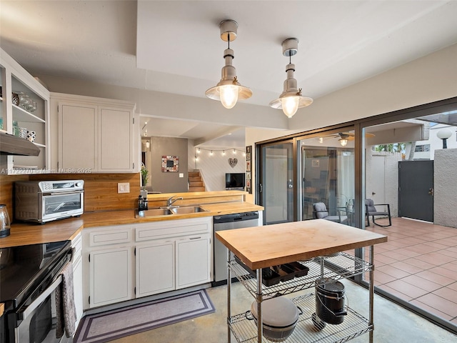 kitchen with decorative light fixtures, stainless steel appliances, tasteful backsplash, white cabinetry, and sink