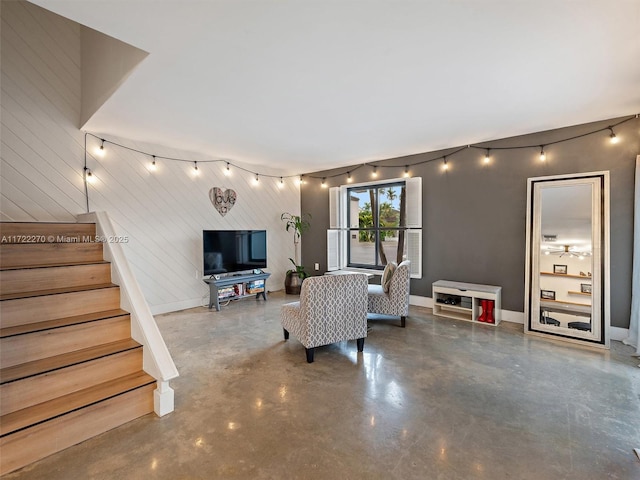 living room featuring wood walls and concrete flooring