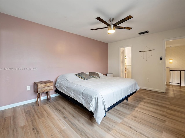 bedroom featuring ceiling fan, light hardwood / wood-style flooring, and connected bathroom