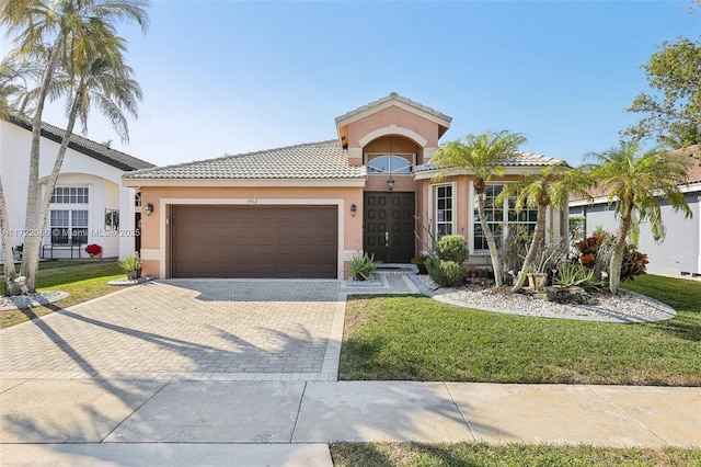 mediterranean / spanish house featuring a garage and a front yard