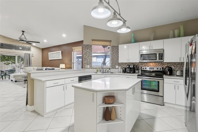 kitchen with pendant lighting, a center island, ceiling fan, appliances with stainless steel finishes, and white cabinetry